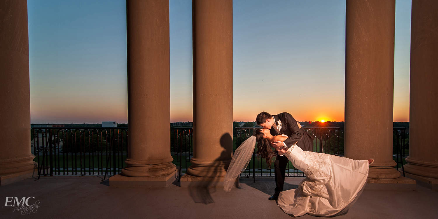 Jonathon kisses Conchita as he dips her with the sun setting in the background at the upper level of Memorial Union with the columns